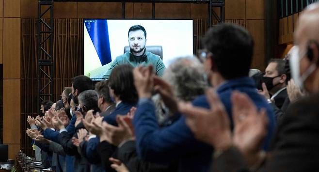 지난 3월 15일 캐나다 의회에서 화상 연설을 하는 볼로디미르 젤렌스키 우크라이나 대통령에게 의회의원들이 기립박수를 보내고 있다. 연합뉴스