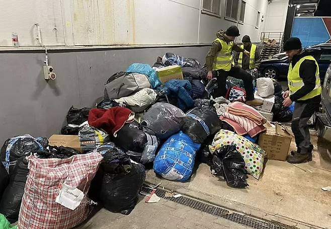 폴란드 국경의 한 주차장에 난민들이 사용할 수 없는 기부품이 산더미처럼 버려져 있다