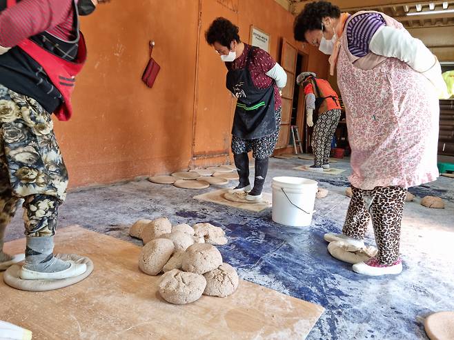 금정산성 누룩을 할머니들이 직접 발로 밟으며 금형작업을 하고 있다. 하루 생산량은 500여개. /박순욱 기자