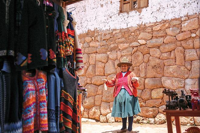 전통방식으로 직물 짜는 방식을 설명하고 있는 친체로의 잉카인.
