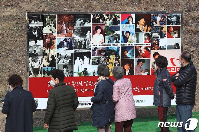 박근혜 전 대통령 귀향과 입주를 하루 앞둔 23일 오후 지지자들이 사저 앞 게시대에 전시된 박 전 대통령 사진을 살펴보고 있다. 2022.3.23/뉴스1 © News1 공정식 기자