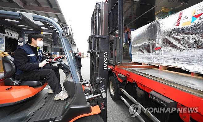 수송차량에 라게브리오 싣는 관계자 (영종도=연합뉴스) 김도훈 기자 = 24일 오후 인천국제공항 보세창고에서 관계자들이 코로나19 경구용(먹는) 치료제 '라게브리오' 2만160명분을 오창 물류센터로 보내기 위해 수송차량으로 옮기고 있다.  2022.3.24 superdoo82@yna.co.kr