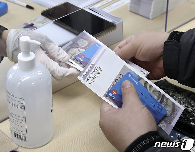울산형 일상회복 희망지원금 지급 첫날인 5일 오전 울산 중구 우정동행정복지센터에서 시민들이 희망지원금 카드를 수령하고 있다. 울산시는 이날부터 28일까지 4주간 울산시민 1인당 무기명 선불카드 8만원과 온누리 상품권 2만원씩 총 10만원을 지급한다. 2022.1.5/뉴스1 © News1 윤일지 기자