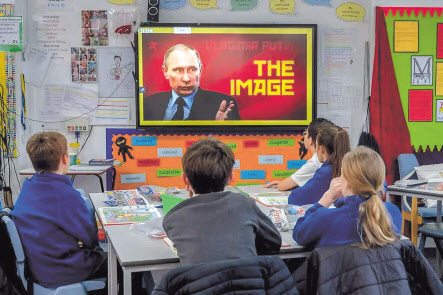 지난 21일(현지시간) 영국 런던 남부 호셤에 위치한 헤론 웨이 초등학교 학생들이 블라디미르 푸틴 러시아 대통령에 대한 정보가 담긴 영상물을 보고 있다. [NYT]