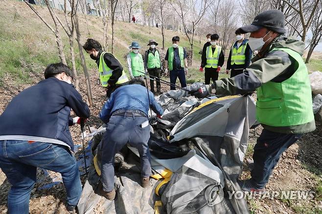 '강제철거되는 텐트' (대구=연합뉴스) 박세진 기자 = 4일 대구 북구 직원과 공공근로자 40여명이 동변동 금호강 고수부지 일대 불법 설치된 텐트 등 시설물을 대상으로 행정대집행을 실시하고 있다. 2022.4.4 psjpsj@yna.co.kr