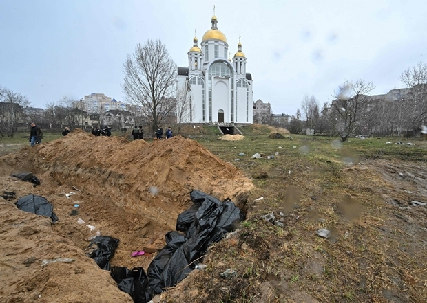 3일(현지시간) 우크라이나 키이우 외곽 부차의 한 교회 뒷마당에서 포착된 집단 무덤. 아나톨리 페도루크 부차 시장은 AFP통신에 약 300구의 시신이 이 집단 묘지에 묻혔다고 말했다. 한 관계자는 교회 뒤 편 구덩이에서 시신 57구가 발견됐다고 말했다./AFP연합뉴스