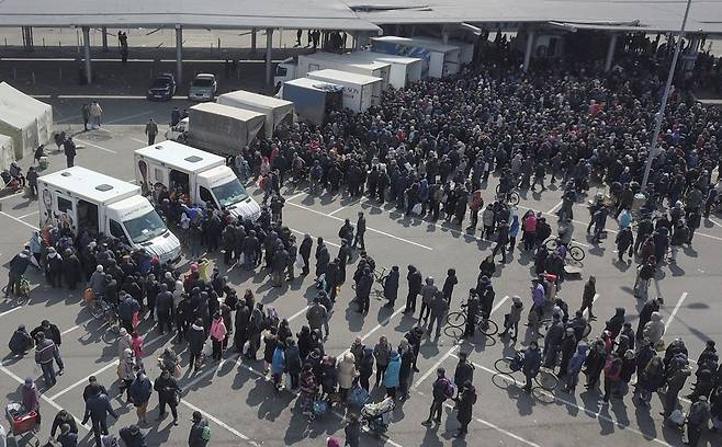 지난 5일 마리우폴 대형 마트의 차량 앞으로 먹을 것을 얻기위해 줄을 선 시민들. 사진=로이터 연합뉴스