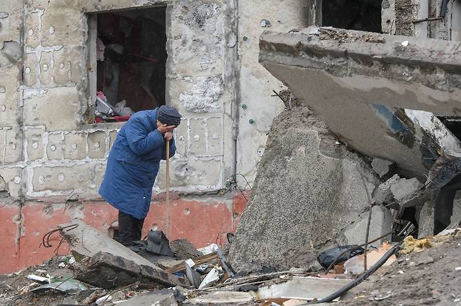 우크라이나 수도 키이우 북서쪽 위성도시 보로댠카에서 지난 9일(현지시간) 한 여성이 러시아군 침공 당시 파괴된 아파트 건물 잔해 속에서 아들의 시신을 찾다가 눈물을 흘리고 있다. / 로이터 연합뉴스