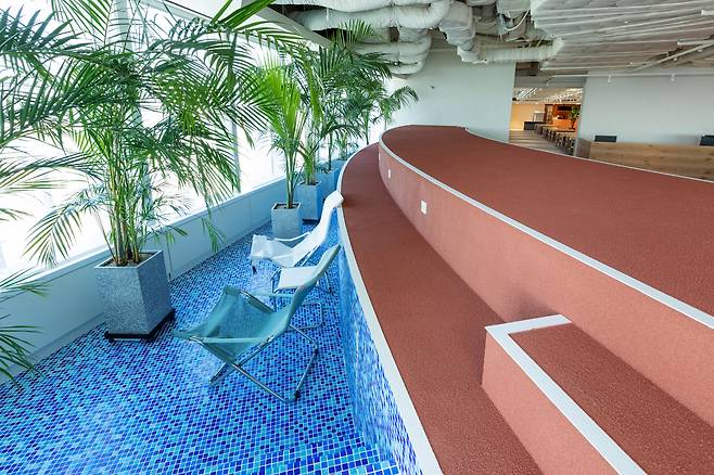 우아한형제들이 잠실롯데타워에 꾸린 '더큰집'의 휴식 공간. 서울 전경이 보이는 자리에 수영장처럼 꾸민 휴식 공간이 자리하고 있다. [우아한형제들 제공]