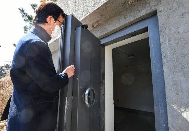 이태구 교수가 지난달 28일 충북 제천 의림지 인근 야산에 본인이 설치한 모형 방공호에서 외부 방폭문의 기능을 설명하고 있다. 제천=이한결 기자