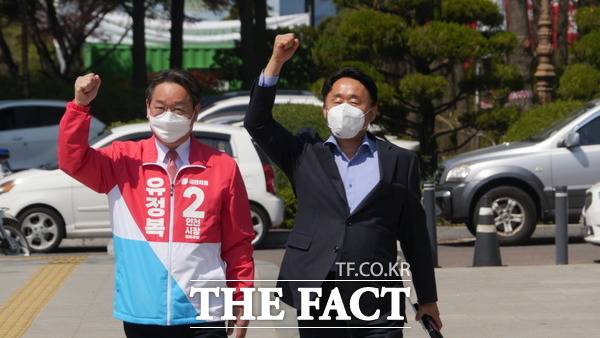 유정복 국민의힘 인천시장 예비후보(왼쪽)와 심재돈 전 동구·미추홀구갑 당협위원장이 17일 인천시청 앞에서 가질 기자회견을 위해 파이팅을 외치며 함께 걸어오고 있다. /인천=지우현 기자