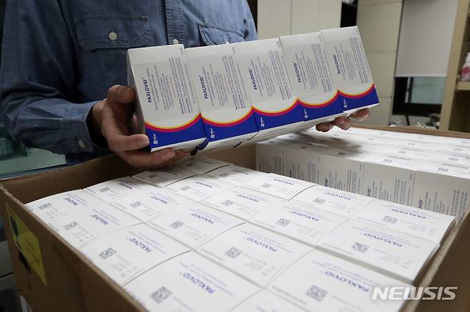 [서울=뉴시스] 김병문 기자 = 지난 6일 오후 서울 성동구 보건소에서 직원이 코로나19 먹는 치료제 팍스로비드를 들어 보이고 있다. 질병관리청 중앙방역대책본부에 따르면 이날부터 전국 보건소에 코로나19 먹는 치료제를 공급해 처방에 활용한다. 이를 통해 요양병원과 요양시설, 정신병원 등에서는 보건소를 통해 먹는 치료제를 받을 수 있다. 2022.04.17. dadazon@newsis.com