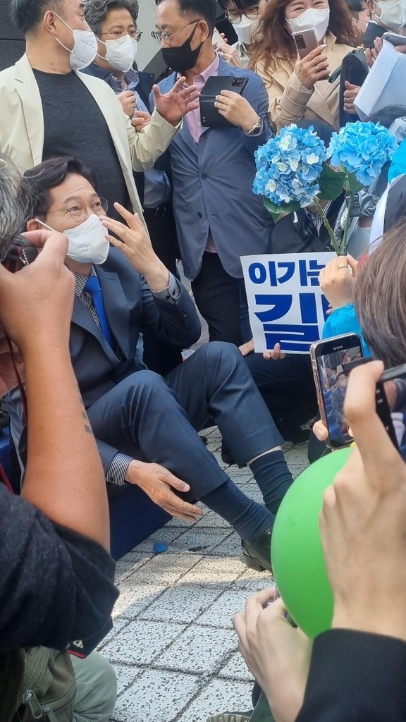 바닥에 앉아 지지자들과 사진 촬영하는 송영길 전 대표 [촬영: 강민경 기자]