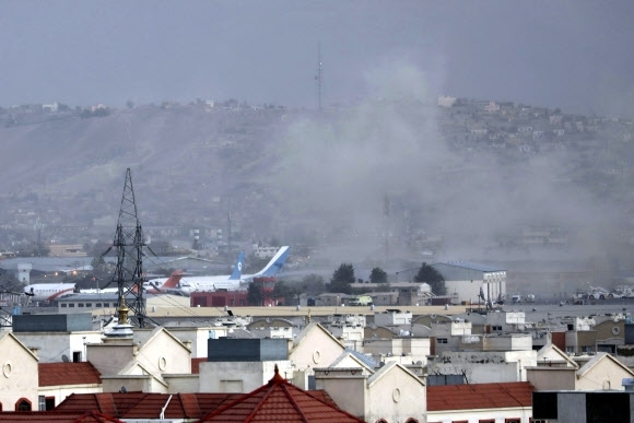 지난해 8월 26일(현지시간) 두 차례 자살폭탄 공격이 발생한 아프가니스탄 수도 카불의 하미드 카르자이 국제공항 안팎에서 폭발로 인한 연기가 카메라에 포착됐다.카불 AP 연합뉴스