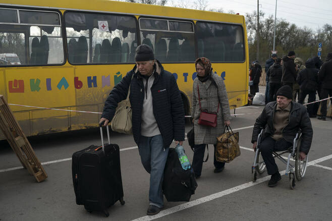 21일(현지시간) 우크라이나 남부 항구도시 마리우폴에서 러시아군의 공격을 피해 탈출한 주민들이 자포리자(자포리지야)에 도착해 난민센터로 향하고 있다. 자포리지야는 우크라이나군이 아직 장악하고 있는 대피도시다./ AP 연합뉴스