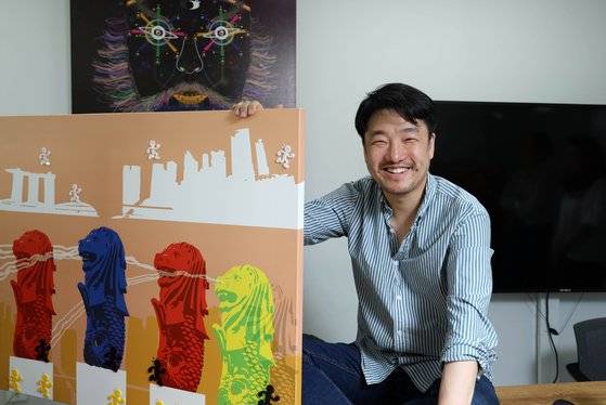 '코인맨'과 함께 한 김일동 작가. 하얀색과 검정색, 노란색 코인맨들은 작품 속 세계의 랜드마크를 거쳐 기부상자에 도착한다. 김상선 기자