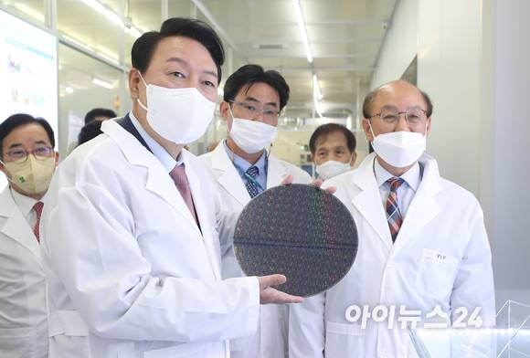윤석열 대통령 당선인이 29일 오전 대전 한국과학기술원(KAIST) 내 나노종합기술원을 방문해 반도체 연구 현장을 둘러보던 중 반도체 웨이퍼 샘플을 들어보고 있다. [사진=인수위 사진기자단]