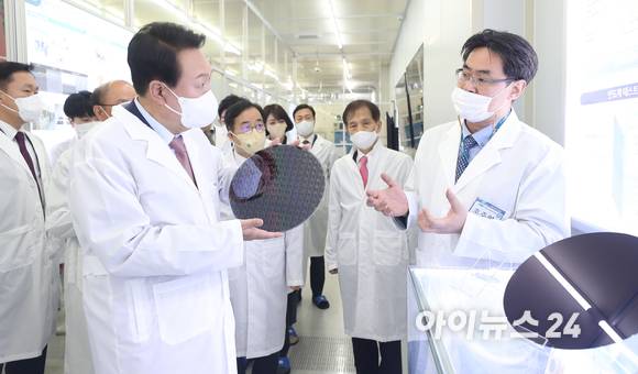 윤석열 대통령 당선인이 29일 오전 대전 한국과학기술원(KAIST) 내 나노종합기술원을 방문해 반도체 연구 현장을 둘러보던 중 반도체 웨이퍼 샘플을 들어보고 있다. [사진=인수위 사진기자단]