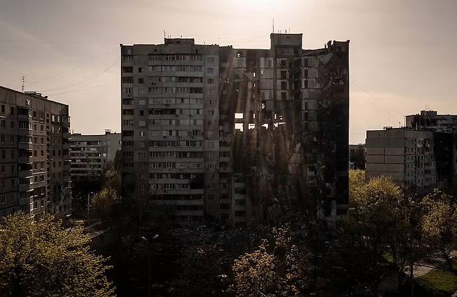 우크라이나 제2 도시 하르키우 인근 지역에서 러시아군의 포격으로 부분적으로 파괴된 아파트 건물을 통해 햇빛이 비치고 있다. / AP 연합뉴스
