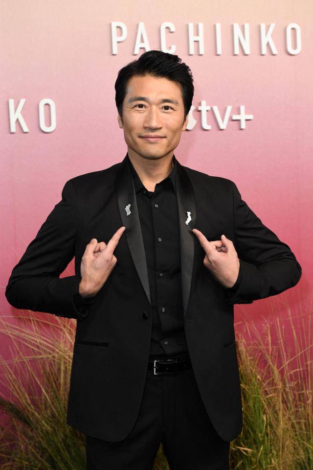 박소희가 3월 미국 로스앤젤레스 아카데미뮤지엄에서 열린 드라마 '파친코' 시사회 레드카펫에서 한반도와 일본 지도 모양의 배지를 양손으로 가리키고 있다. 로스앤젤레스=AFP 연합뉴스