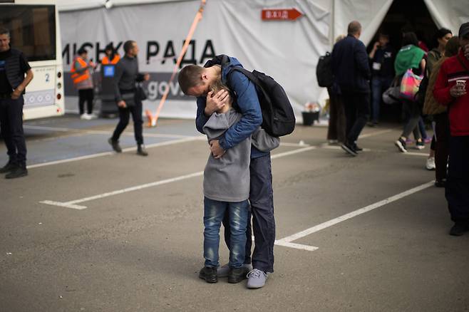 우크라이나 자포리자 난민센터에서 지난 2일(현지시간) 피란민 안드리 페도로프가 아들 마카르와 포옹하고 있다. / AP 연합뉴스