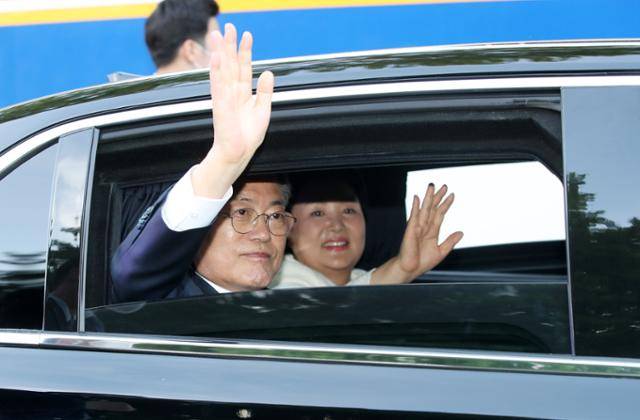 문재인 대통령과 김정숙 여사가 9일 청와대 앞에서 차량에 탑승, 문재인 정부의 마지막 밤을 보낼 서울시내 모처로 이동하면서 시민들에게 인사하고 있다. 뉴시스
