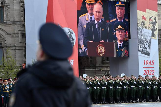 러시아 모스크바의 붉은광장에서 9일(현지시간) 열린 2차 세계대전 전승기념식에서 병사들 머리 위에 설치된 대형 스크린을 통해 블라디미르 푸틴 대통령의 연설 모습이 중계되고 있다. 모스크바 | AFP연합뉴스