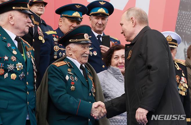 [모스크바=AP/뉴시스] 블라디미르 푸틴 러시아 대통령이 9일(현지시간) 러시아 모스크바의 붉은 광장에서 열린 제2차 세계대전 종전 제77주년(전승절) 기념 열병식에 참석해 참전 노병들과 악수하고 있다. 2022.05.09.