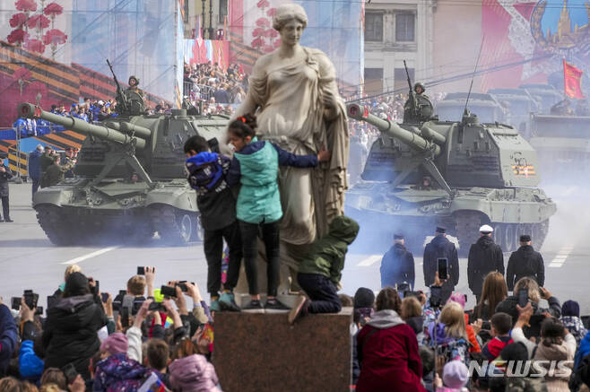[모스크바=AP/뉴시스] 9일(현지시간) 러시아 모스크바의 붉은 광장에서 제2차 세계대전 종전 제77주년(전승절) 기념 열병식이 열려 시민들이 자주포 행렬을 구경하고 있다. 2022.05.09.