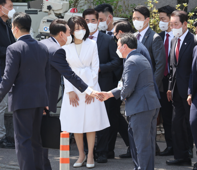 윤석열 대통령과 김건희 여사가 10일 서울 용산구 집무실로 향하며 성장현 용산구청장 등 관계자들과 인사를 나누고 있다. 연합뉴스