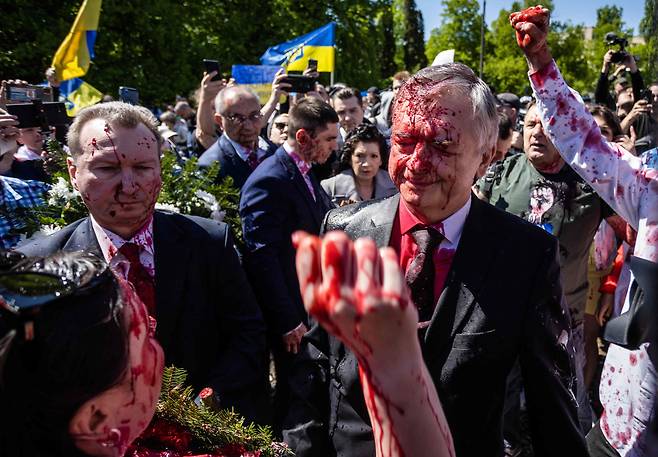 지난 5월 9일 세르게이 안드레예프 주 폴란드 러시아 대사가  나치 독일에 대한 소련군의 승리 77주년 기념일을 맞아 폴란드 바르샤바에 있는 소련군 전사묘지를 참배하려다 우크라이나 전쟁에 항의하는 시위대가 던진 붉은색 페인트를 뒤집어 쓰는 봉변을 당했다./AFP 연합뉴스