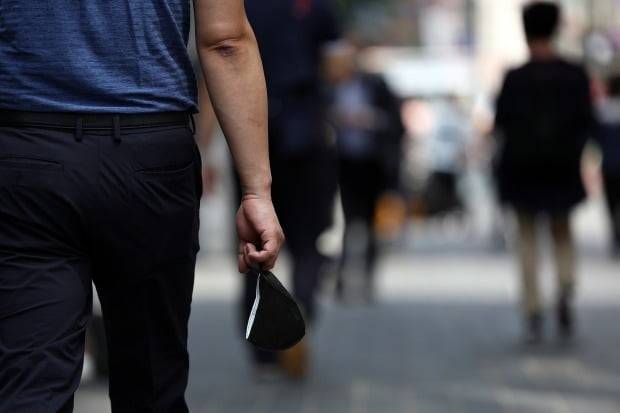 마스크를 벗어 손에 쥔 채 명동 거리를 걷는 서울 시민. /사진=연합뉴스