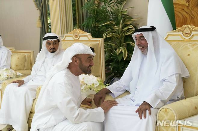 [AP/뉴시스] 2019년 5월 사진으로 셰이크 칼리파 빈 자이예드 알 나히안 UAE 대통령 겸 아부다비 국왕이 알바탄 궁에서 이복동생인 셰이크 모하메드 빈 자이예드 알 나히안 왕세자의 인사를 받고 있다. 이를 UAE의 다른 토후국인 아즈만의 후마이드 토후가 보고 있다.
