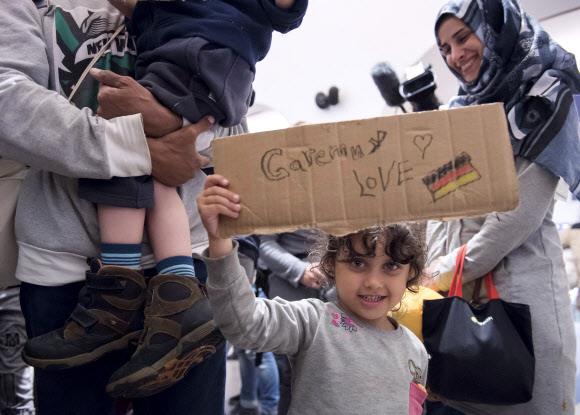 2015년 9월 시리아 내전을 피해 독일 중부도시 잘펠트 기차역에 도착한 한 난민 소녀가 ‘사랑해요 독일’이란 문구와 그림이 적힌 골판지를 들어 보이고 있다.서울신문 DB
