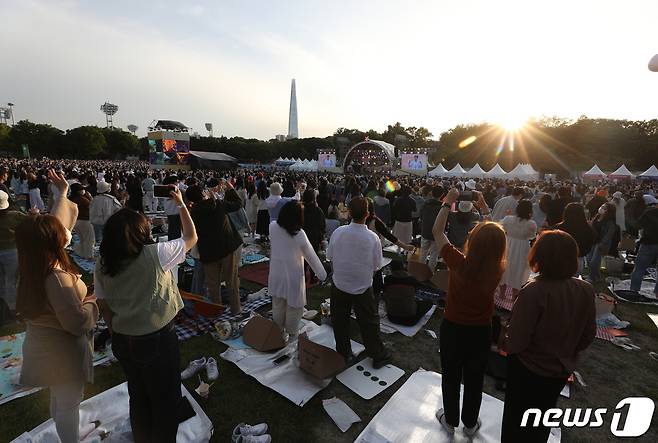 14일 오후 서울 송파구 올림픽공원 88잔디마당에서 열린 뷰티풀 민트 라이프에서 시민들이 공연을 즐기고 있다. 오는 15일까지 열리는 뷰티풀 민트 라이프에서는 다양한 아티스트들의 무대가 펼쳐지며 50인 이상이 모이는 실외 공연장이므로 마스크 착용이 의무화된다. 2022.5.14/뉴스1 © News1 신웅수 기자