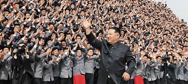 5월 1일 평양… 마스크도 없이 다닥다닥 사진 촬영 - 북한 김정은 국무위원장이 지난 1일 항일 빨치산 결성 90주년 기념 야간 열병식(4월 25일)에 참석했던 평양 시내 대학생, 근로 청년들을 격려하는 자리에 참석해 손을 흔들고 있다. 김정은은 청년 수만 명과 조를 나눠 릴레이 사진 촬영을 했다. 김정은을 포함해 모두가‘노 마스크’였다. /조선중앙TV