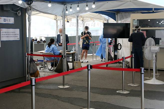 13일 오전 서울 중구 서울역광장에 마련된 신종 코로나바이러스 감염증(코로나19) 임시선별진료소에서 시민들이 검사를 기다리고 있다. [뉴스1]