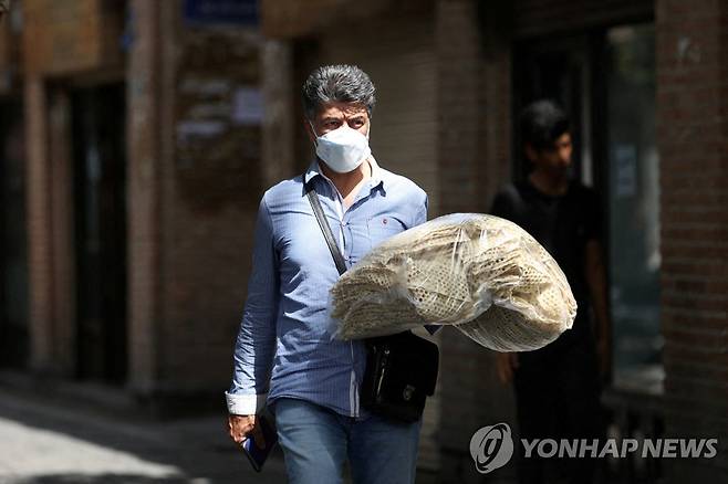 지난 1일 이란 테헤란에서 한 남성이 빵 더미를 들고 있다. [로이터=연합뉴스 자료사진. 재판매 및 DB 금지]