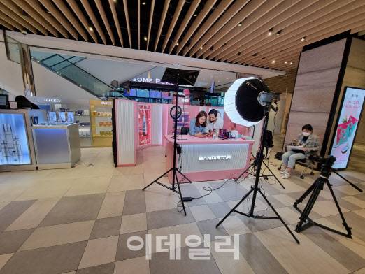 ▲신세계면세점 명동점 11층에 마련된 ‘더뷰티라이브’ 부스에서 중국인 2명이 뷰티 제품을 판매하는 라이브방송을 하고 있다. (사진=윤정훈 기자)