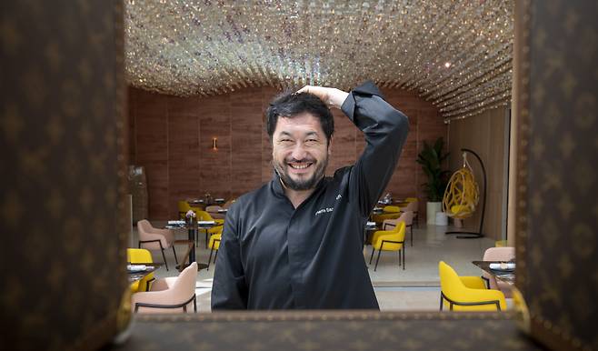 다음 달 10일까지 열리는 루이비통의 임시 레스토랑을 총괄하기 위해 한국을 찾은 한국계 프랑스인 셰프 피에르 상 보이에. 환하게 웃는 그의 모습 뒤로 천장에 매달려 샹들리에처럼 반짝이는 1만3899개의 루이비통의 모노그램 꽃송이 장식이 보인다. /김지호 기자