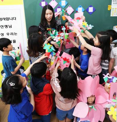 스승의 날을 맞아 경기도의 한 초등학교 학생들이 직접 만든 카네이션을 담임교사에게 전하고 있다. / 연합뉴스