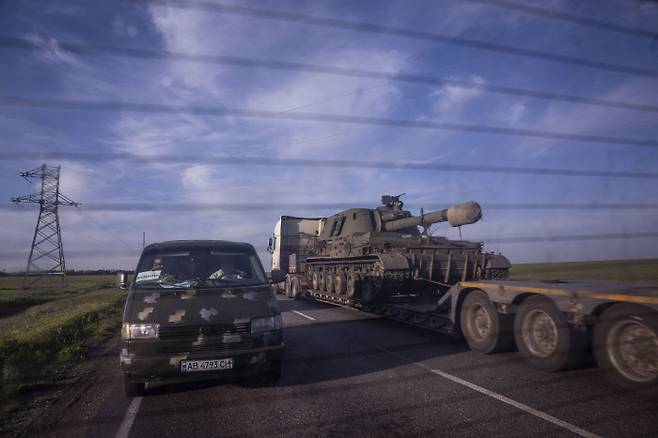 지난 12일(현지시간) 우크라이나 동부 도네츠크주에서 우크라이나군이 자주포를 트럭에 싣고 이동하고 있다. AP연합뉴스