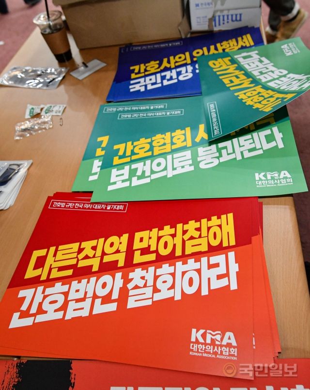 15일 서울 영등포구 서울시의사회관에서 개최한 '간호법 규탄 전국 의사 대표자 궐기대회'에서 관계자들이 간호법을 규탄하는 손팻말을 나눠주고 있다.