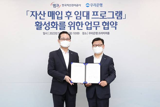 우리은행이 지난 13일 서울 중구 우리은행 본점에서 한국자산관리공사(캠코)와 자산매입 후 임대프로그램 활성화를 위한 업무협약을 체결했다. 이원덕 우리은행장(사진 오른쪽)과 권남주 한국자산관리공사 사장(사진 왼쪽)이 기념촬영을 하고 있다./사진제공=우리은행