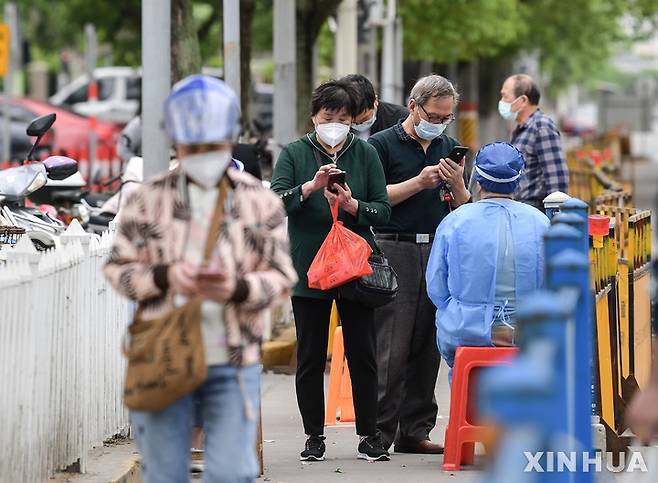 [상하이=신화/뉴시스] 일부 이동제한이 풀린 중국 상하이 자딩구에서 10일시민들이 시장에 들어가기 전에 코로나10 핵산검사 증명서를 보여주고 있다. 2022.05.13