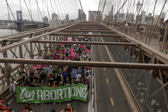 브루클린 다리 위 ‘우리의 낙태’ 플래카드 - 낙태권 보장 시위에 참가한 시민들이 14일(현지시간) 미국 뉴욕 브루클린 다리 위를 행진하고 있다. 2022.5.15 AP 연합뉴스