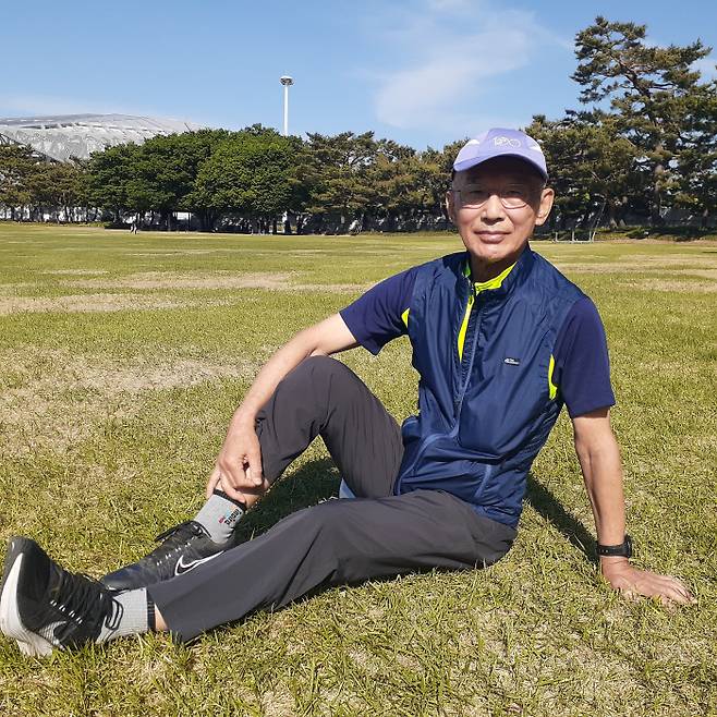 정형외과의사인 이경두 정근한방병원 양방원장이 자신이 달리기를 처음으로 시작한 올림픽공원 잔디밭에서 앉아 포즈를 취하고 있다. 김세훈 기자