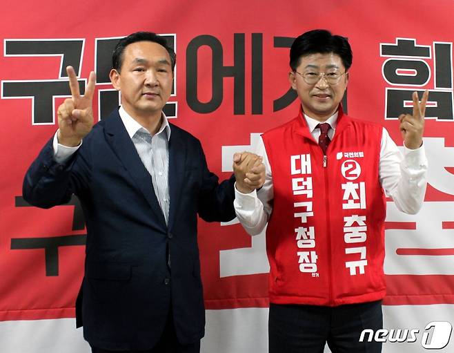 국민의힘 박희진 전 대전시의원이 16일 최충규 대덕구청장 후보 선거사무소를 방문해 최 후보와 손을 잡고 손가락으로 'V자'를 그려보이고 있다.(최충규 후보 선거캠프 제공)© 뉴스1