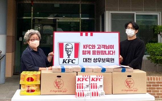 KFC는 아이들을 위한 치킨 기부 미담으로 화제가 된 직장인 김유민씨와 함께 지난 13일 대전 성우보육원에 간식을 기부했다고 16일 밝혔다. (왼쪽부터)김익자 성우보육원장과 고객 김유민씨가 기념촬영을 하고 있다. / 사진=KFC 제공