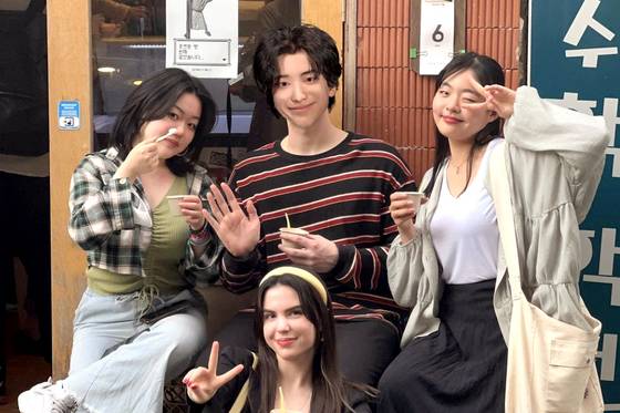 Theo, a virtual human, takes a photo with his friends. [SCREEN CAPTURE]